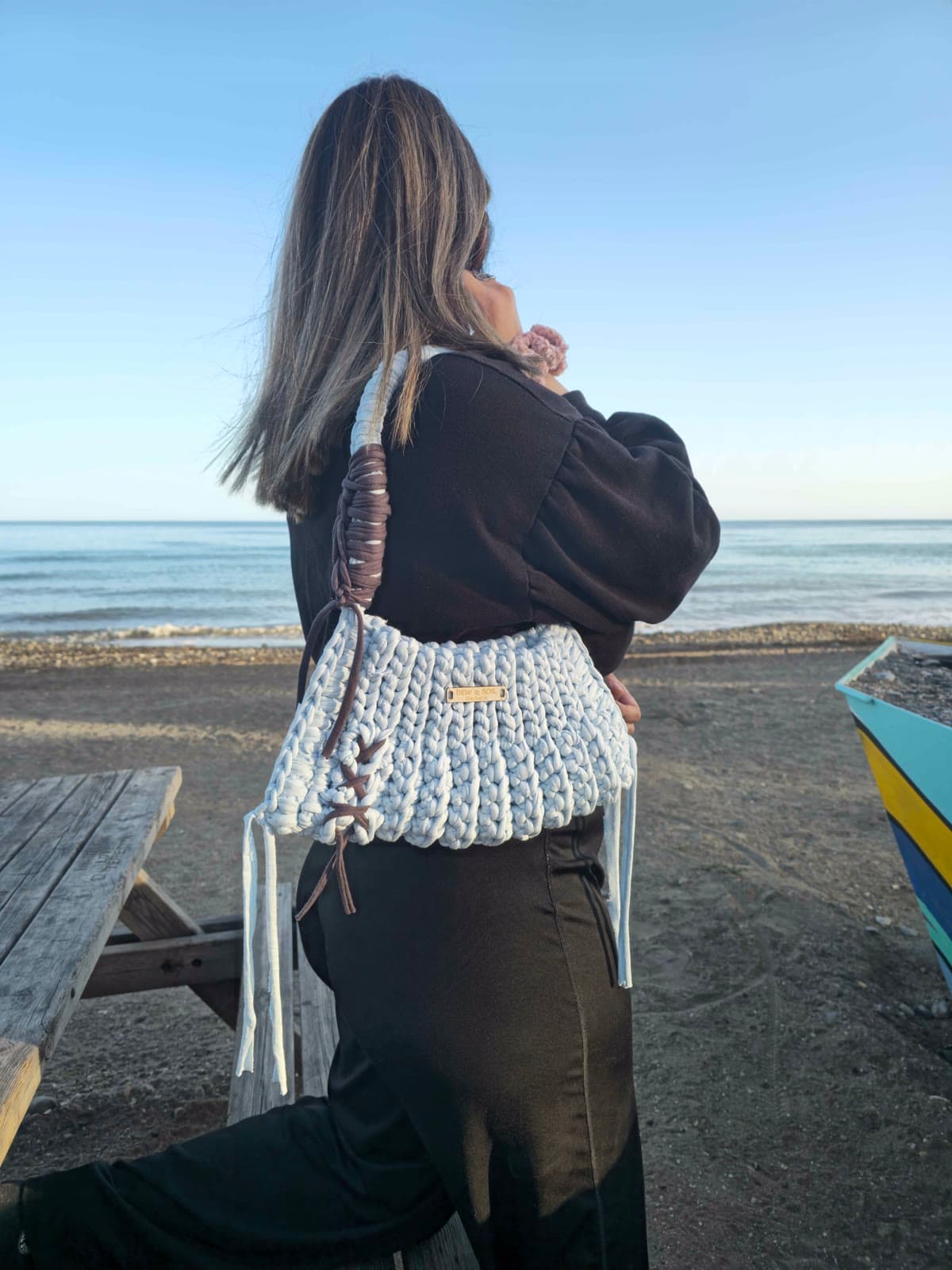 Sky Blue Crochet Tote — held in hand by the sea, blue crochet with brown leather accents
